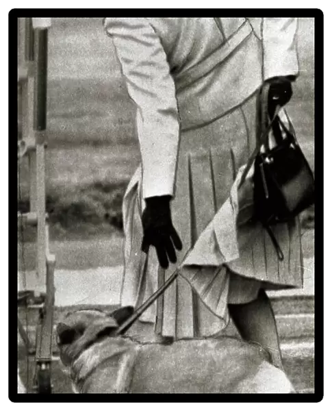 Queen Elizabeth II tries to bring a Corgi to heel at Aberdeen airport September