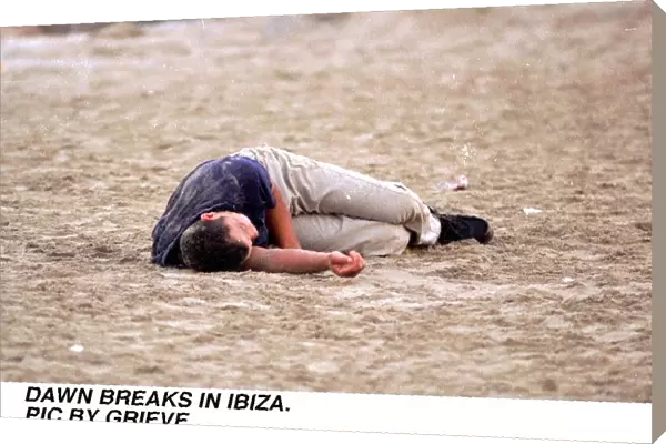 Dawn breaks in Ibiza Spain Drink Drunk youth Young man sleeps it off on the beach