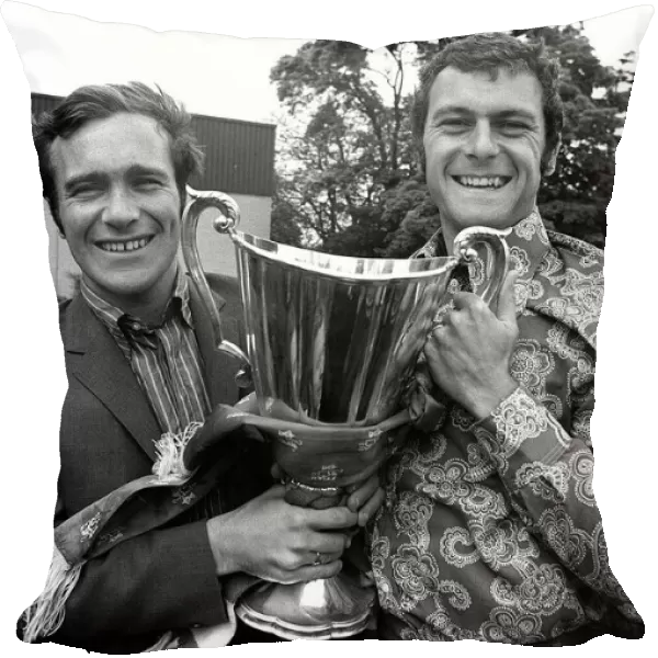 Ron Harris and Keith Weller of Chelsea hold the trophy aboard sn open top bus on a