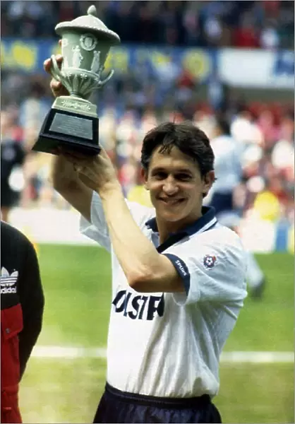 Tottenham Hotspurs striker Gary Lineker holds aloft a trophy presented by Bryan Robson