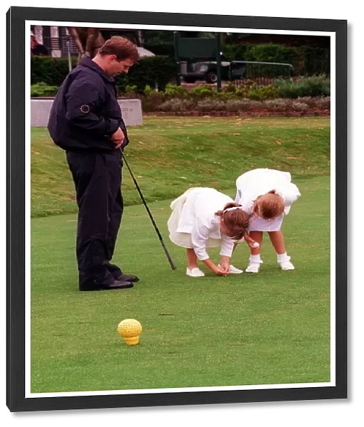 Prince Andrew and daughters Beatrice (R) and Eugenie, August 1998 Placing a golf