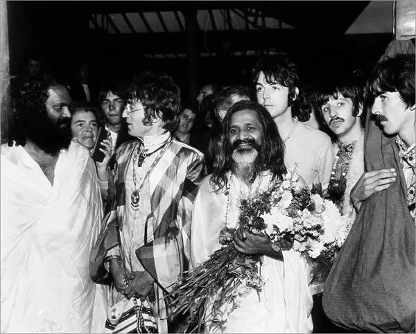 The Beatles with the Maharishi Mahesh Yogi who is clutching bundles of flowers Beatles