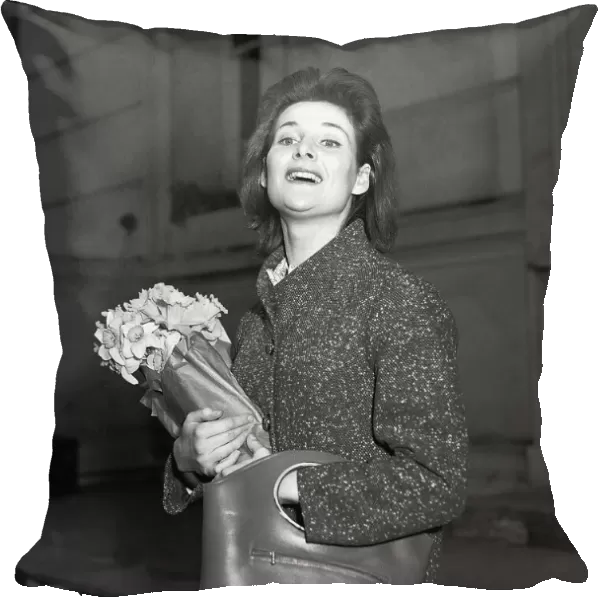 Actress Adrienne Corrie holding a bunch of flowers April 1956