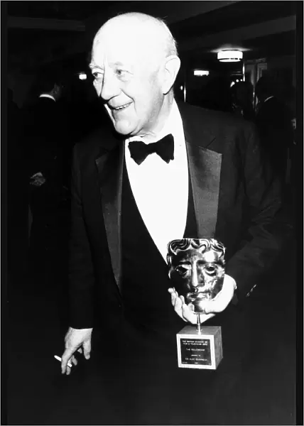 Alec Guinness actor holding BAFTA award in March 1989
