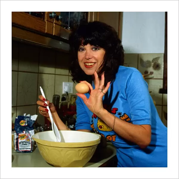 Sally James in kitchen making cake September 1981