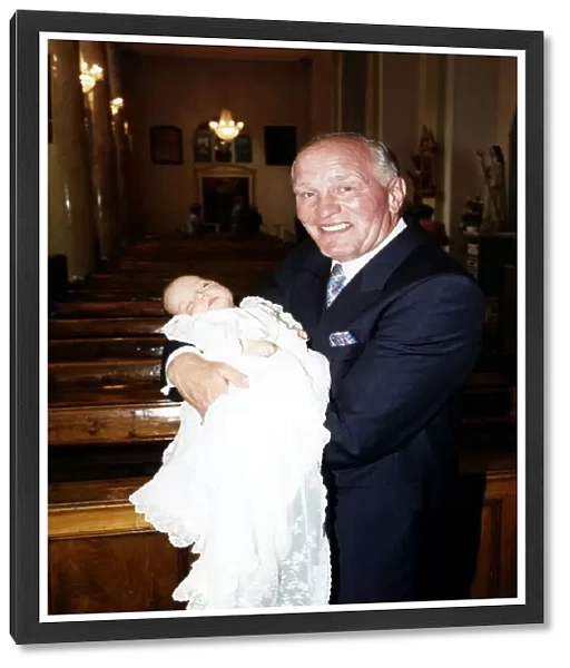 Henry Cooper, Boxing and Sports Personality holding his new grand child at Christening