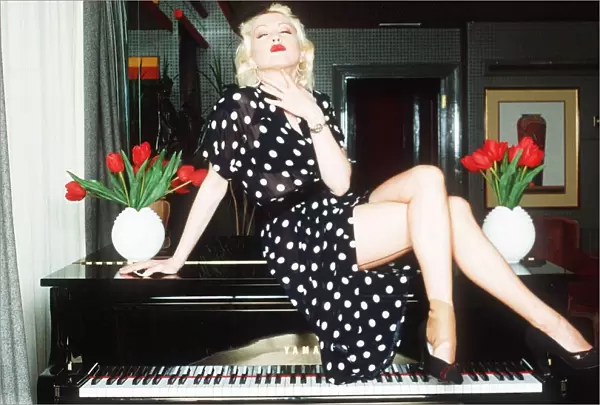 Cyndi Lauper Singer Actress sitting in top of grand piano in black