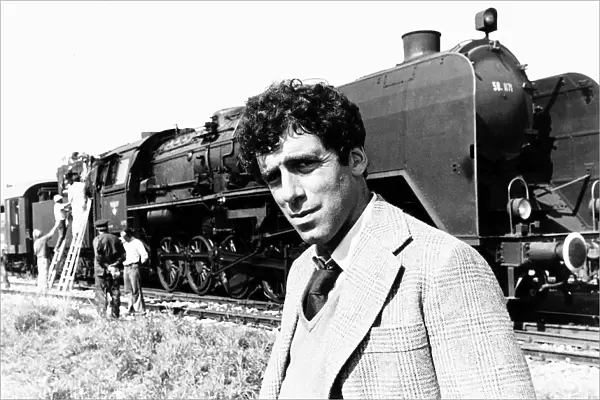 Elliott Gould actor standing in front of a steam train in a scene from the film The Lady