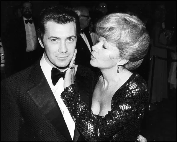 Lewis Collins Actor has his face caressed by Ingrid Pitt at the premiere of his film