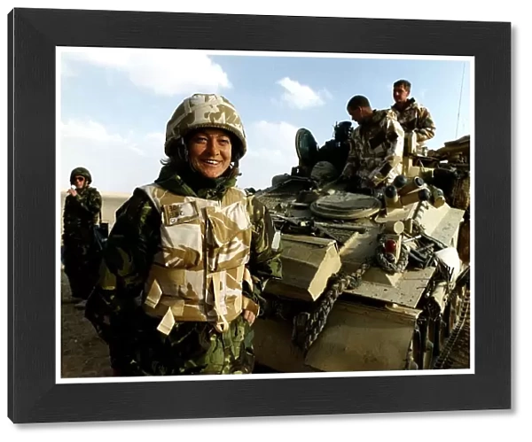 Kate Adie the foreign correspondent for the BBC stands in fatigues alongside soldiers