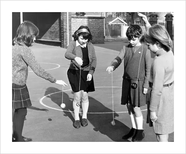 School children playing yoyo games in the school yard. March 1967