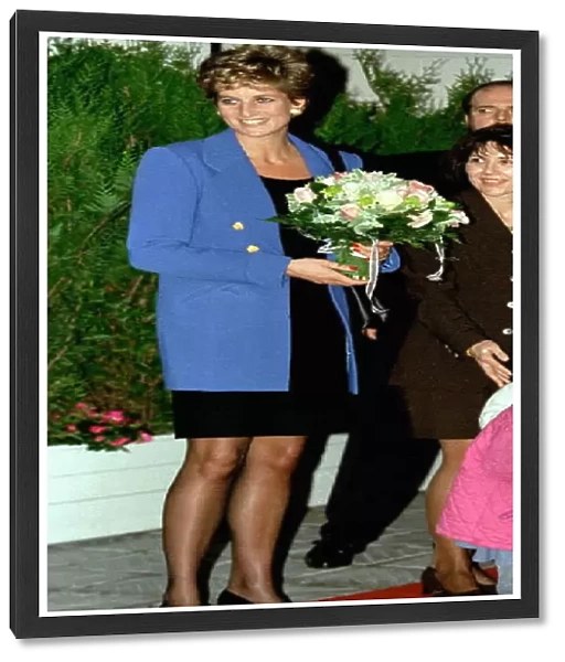 Diana, Princess of Wales, receives a bouquet of flowers from an unidentified girl as she