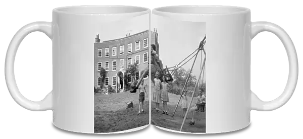 Children playing on the swings at Beech Hill House convalescent home in Berkshire