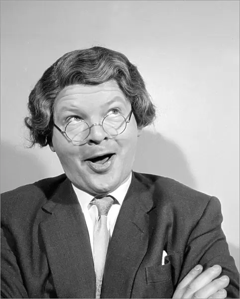 Comedian Benny Hill pictured at home wearing a wig and glasses May 1958