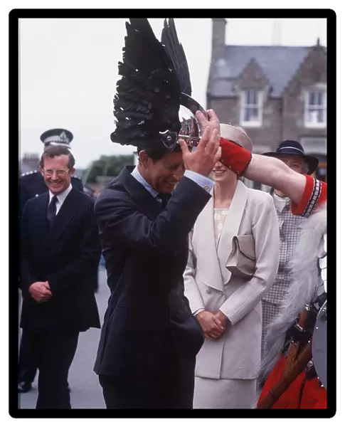 Prince Charles tries on a viking helmet watched by Princess Diana
