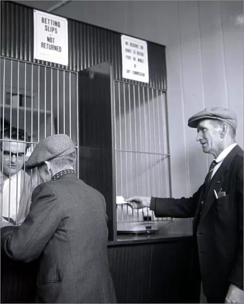 Punters placing their bets inside William Massie betting shop in Bethnal Green