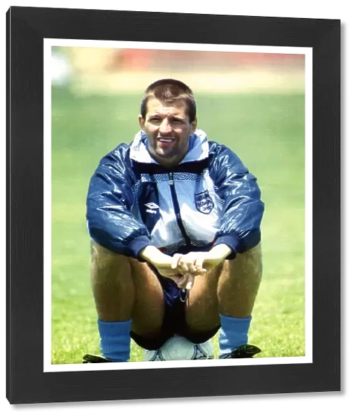 England footballer Steve Bull sitting on a football as he takes a break from training