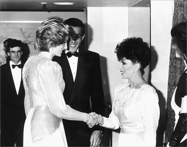 Princess Diana shakes hands with actress Joan Collins at a Bruce Oldfield London fashion