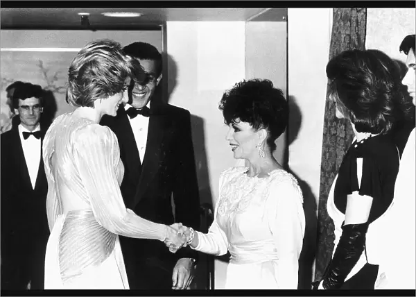 Princess Diana shakes hands with actress Joan Collins at a Bruce Oldfield London fashion