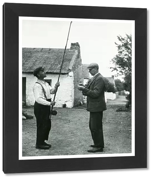 John Barrett and boatman Dick Burke enjoy a 'tall: fishing story together circa 1947