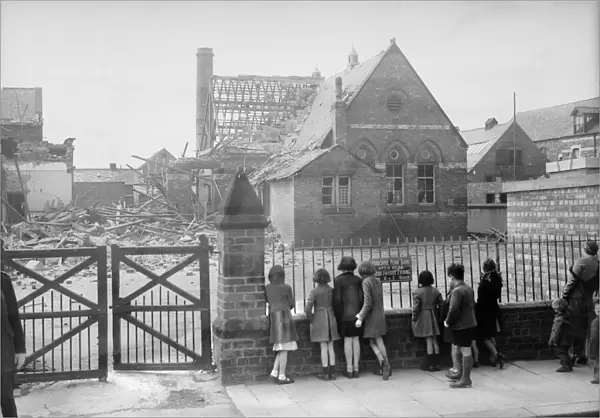 Bomb damage at Saltburn, children looking at a bombed building from a metal fence