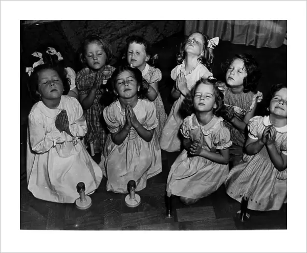 Children kneeling saying prayers. Circa 1940s
