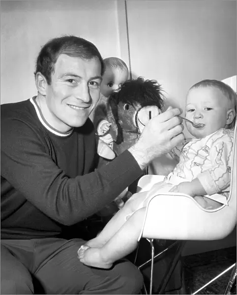 Burnley football player Ralph Coates feeds his new baby girl Lisa. December 1969