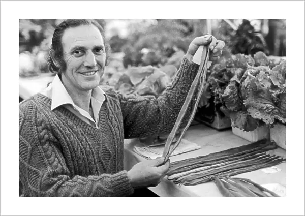 A man holding a selection of runner beans which are in a competition at Egton