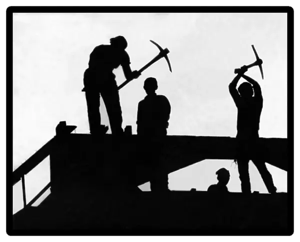 A silhouette of four demolition workers perched high above Newgate Street