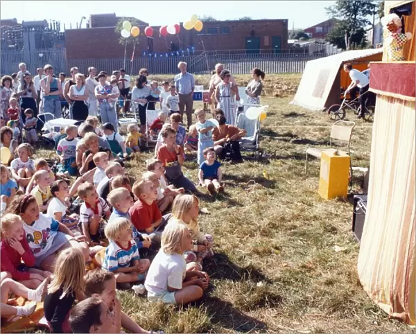 Youngsters are entertained by a Punch and Judy show at Carlin How carnival