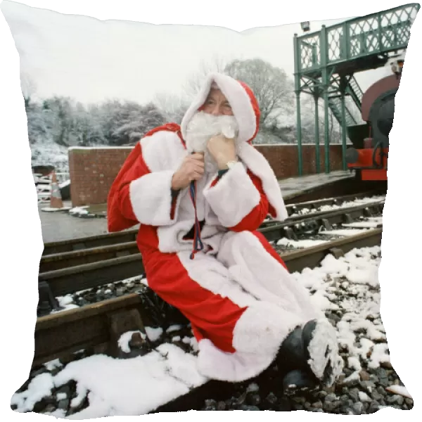 Santa stopped in his tracks. Father Christmas sitting on railway tracks