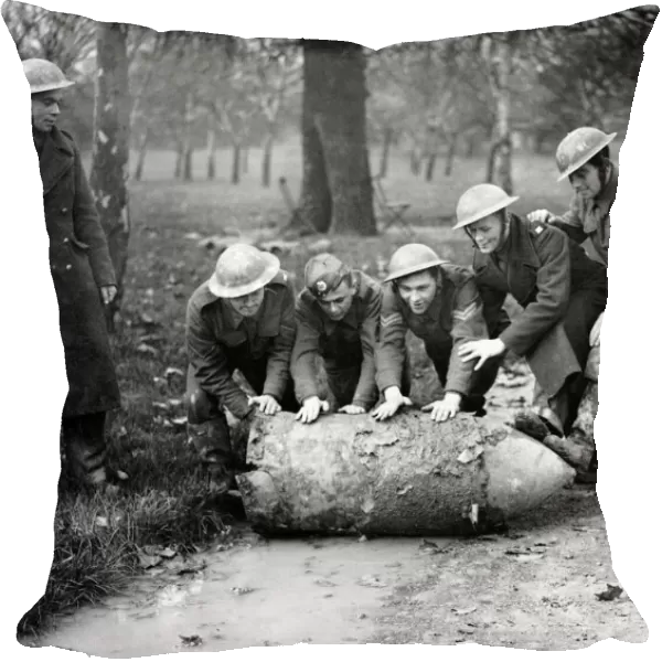 Members of a army bomb disposal squad rolling a unexploded German bomb through a London
