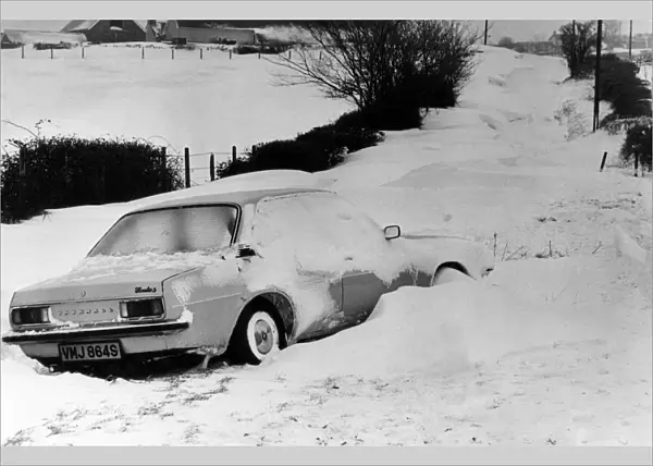 A car is left in a deep snow drift on the road from Culverhouse Cross to St Lythans near