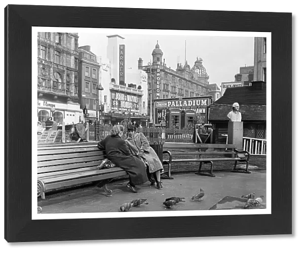 Feeding birds in Leicester Square, London, during lunch hour. 8th March 1954