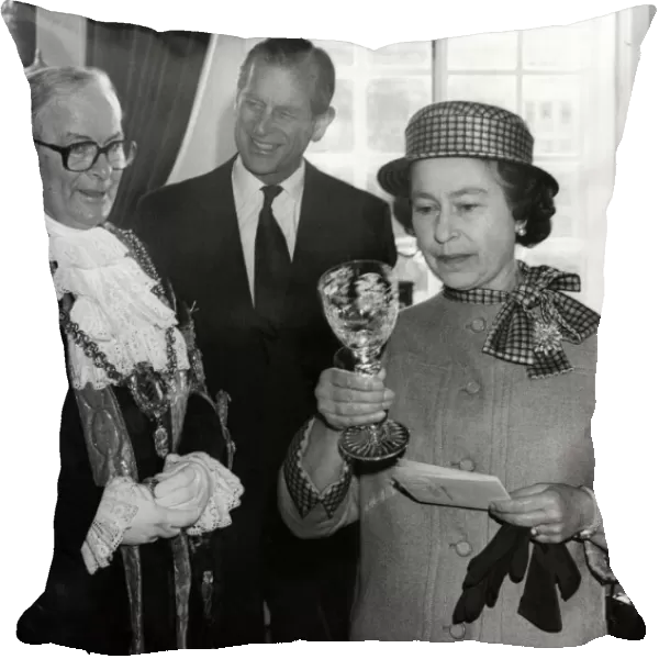 The Queen examines a Royal Doulton crystal goblet presented to her by the Lord Mayor