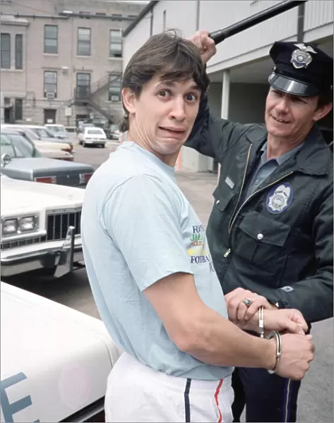 England football star Gary Lineker, is handcuffed by a police officer during a visit to a