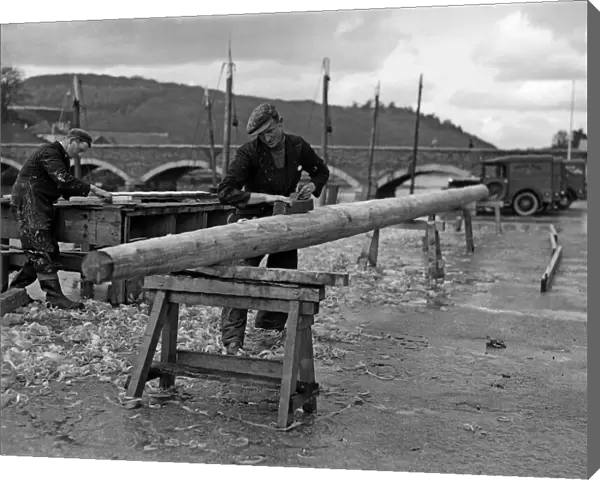 Carpenters seen here making a new mast for a fishing boats moored in the Cornish fishing