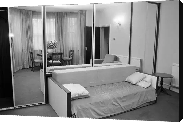 Interior view of a flat, showing the living room area, mirrored wardrobe and sofa bed