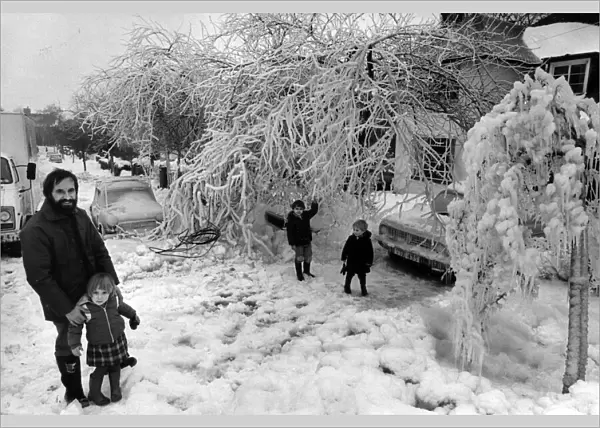 Mr Robert Cowley, of Cyncoed in Cardiff, outside his ice covered garden with his children