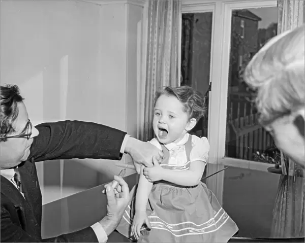 A young patient looks on with trepidation whilst having her polio vaccination