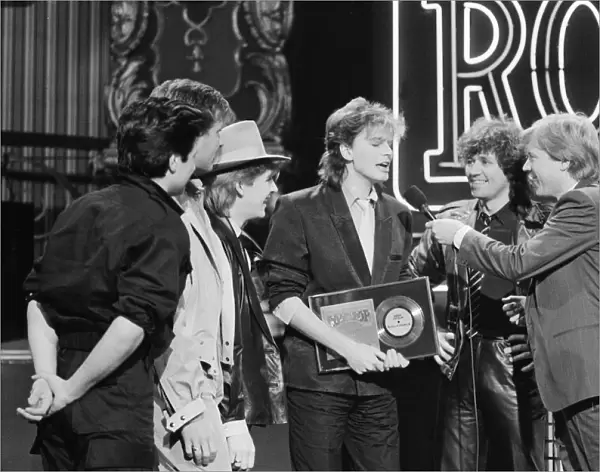 John Taylor, bass player with Duran Duran, receives an award from DJ Kid Jensen
