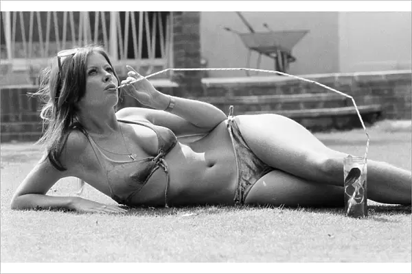 Vicki Michelle, British actress, relaxes in her garden with a cold drink, Epping, Essex
