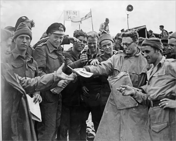 Daily Mirror war correspondent handing out copies to the troops on the Normandy invasion