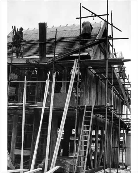 Workmen in action roofing old houses from Much Park Street, Coventry