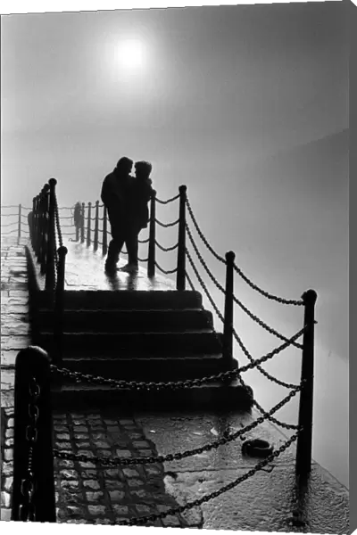 A couple enjoy the magic mood created by the fog at Liverpools Albert Dock