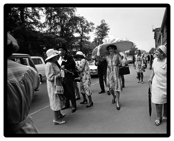 Royal Ascot, first day. Dame Edna Everage wearing a huge, five foot wide hat