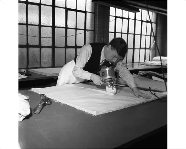 Latex being cut for straps for corsets and girdles at the Spirella Corset factory in