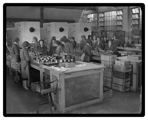 Female workers putting lids on tins of Mansion Polish