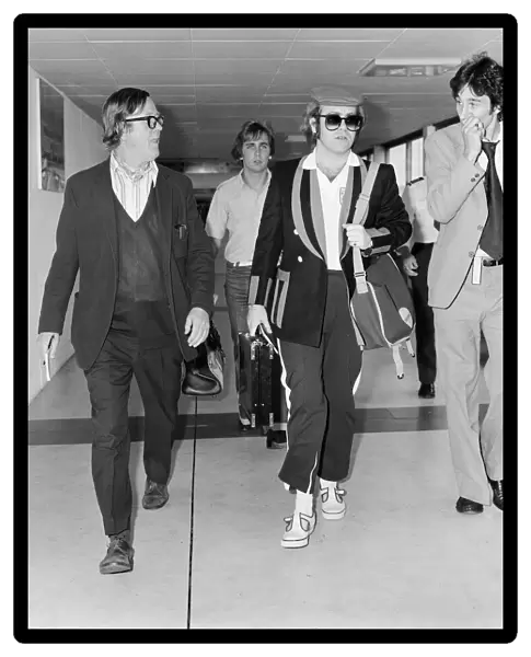 Elton John, departs London Heathrow, heading for Los Angeles. 26th June 1977