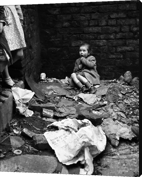 Slum housing in Salford. Four year old Lyn Greenhalgh. The rubble is hers to play with
